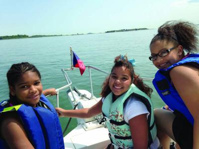 Cruisin' Dorchester Bay: Three members of the Boys and Girls Club of Dorchester enjoy the waters of the Boston Harbor thanks to the Dorchester Yacht Club.     Photo courtesy the Boys and Girls Club of Dorchester